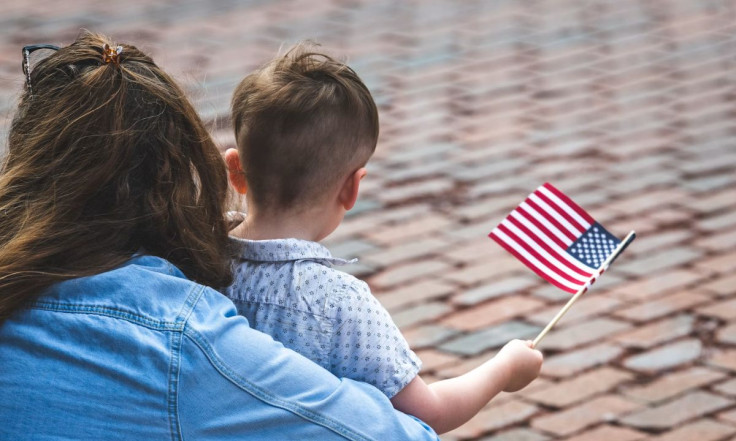 Woman and child holding small american flag.