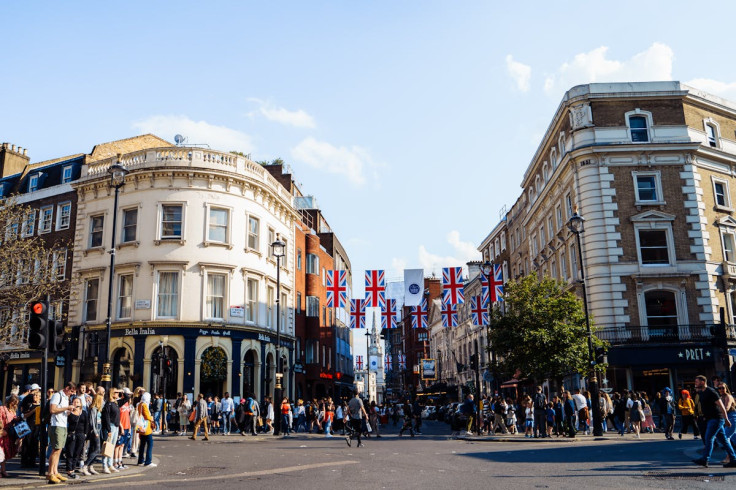 Crowded London street showcasing historic architecture and Union Jack flags