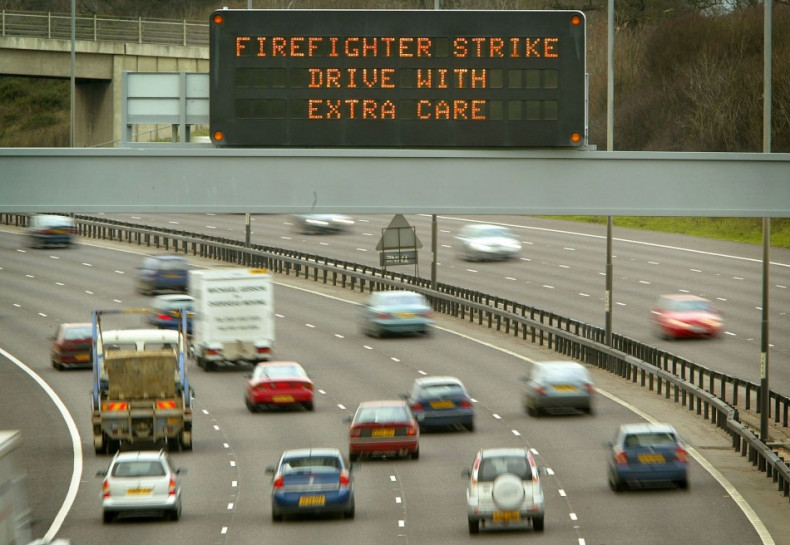A SIGN ENCOURAGING MOTORISTS TO DRIVE WITH CARE OVERLOOKS THE M25 MOTORWAY IN BUCKINGHAMSHIRE.