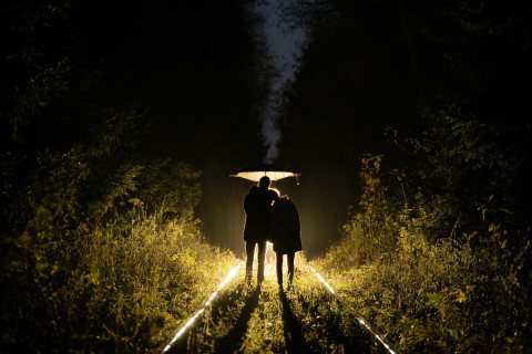 Two figures facing a source of light