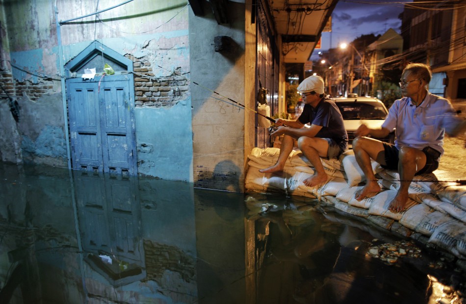Residents fish from a sandbag barrier built to protect their neighborhood from floods advancing into central Bangkok Residents fish from a sandbag barrier built to protect their neighborhood from floods advancing into central Bangkok