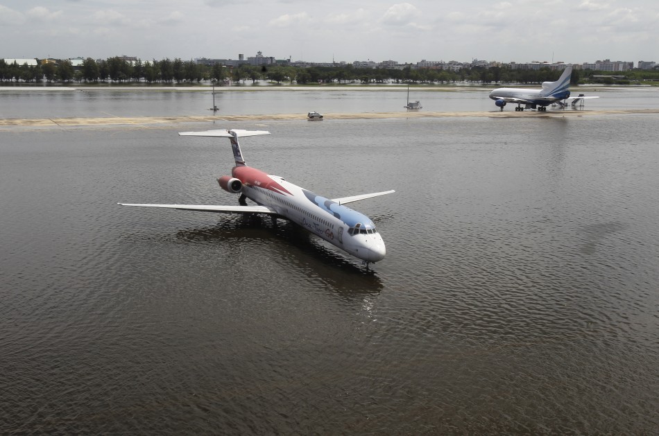 A One-Two-GO Airlines plane is seen parked on a flooded tarmac at Don Muang airport in Bangkok