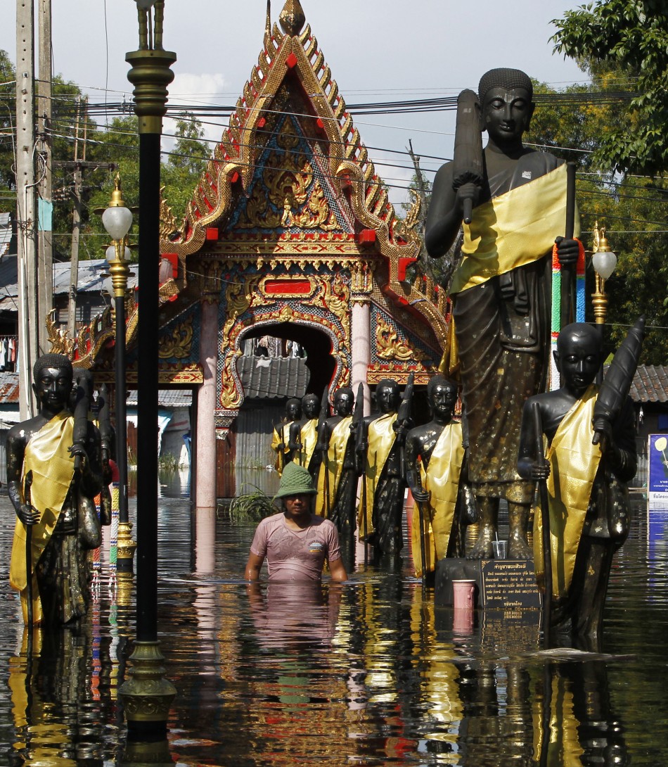 A man wades through a flooded temple in Don Muang district in Bangkok