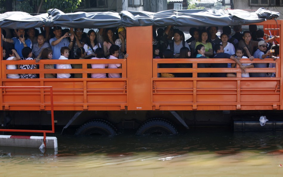 People are evacuated on trucks from a flooded area at Bang Phlat district in Bangkok