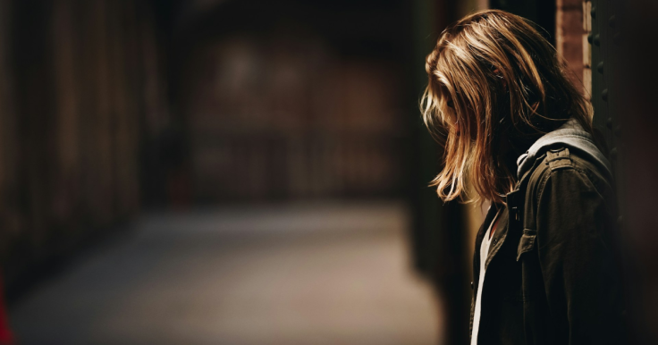 Girl standing in a dim corridor