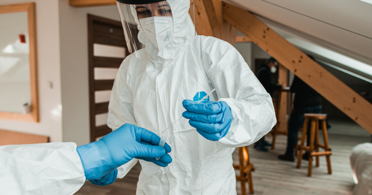 Professionals in PPE gear conducting COVID-19 antigen testing