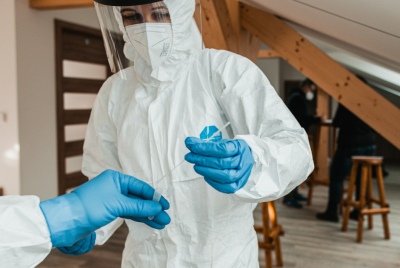 Professionals in PPE gear conducting COVID-19 antigen testing