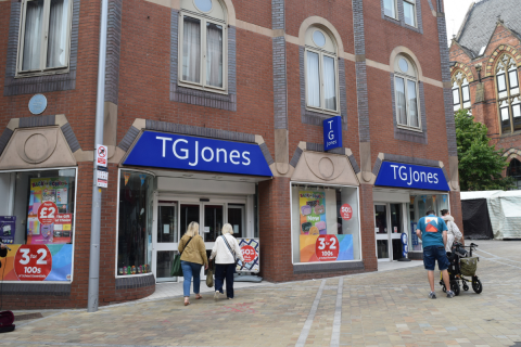 Shoppers walk past a TG Jones store on Lands Lane