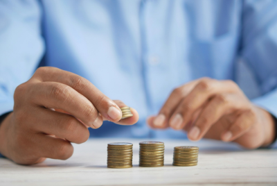 A person arranging stacks of coins of different heights