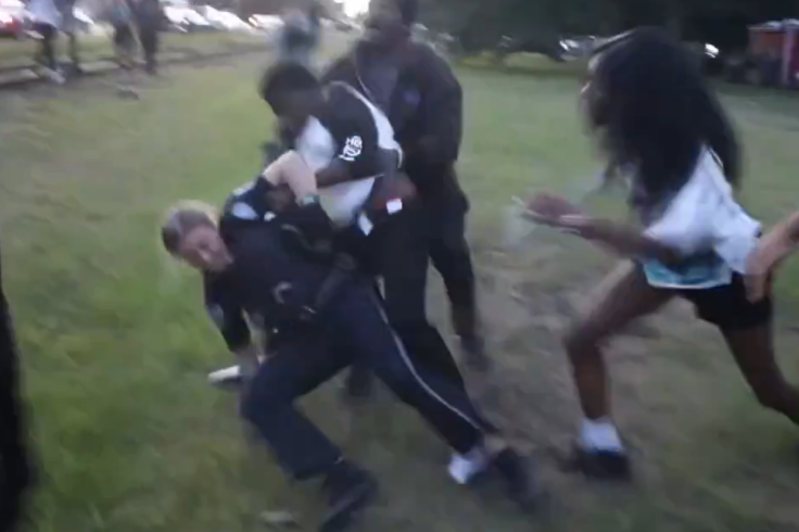 Female police officer being dragged by teens