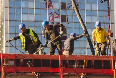 A group of construction workers in safety gear actively working