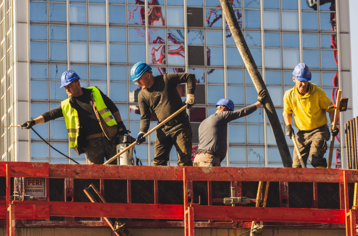 A group of construction workers in safety gear actively working