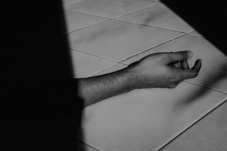 Hand lying on a tiled floor
