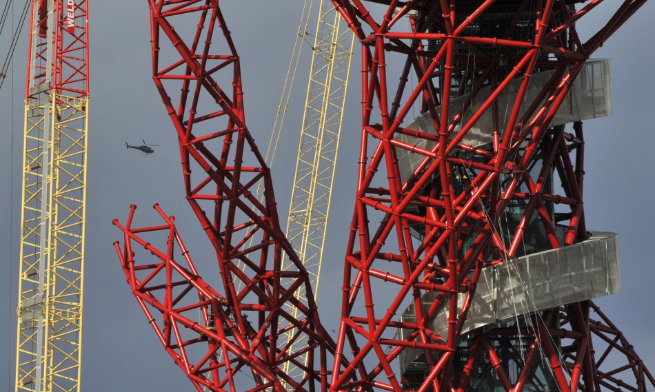 A helicopter flies near the Anish Kapoor-designed ArcelorMittal Orbit tower at the Olympic site at Stratford in east London, on October 7, 2011.