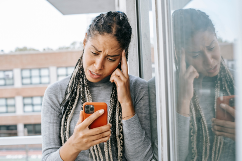 Frustrated woman checking phone during WhatsApp photo outage