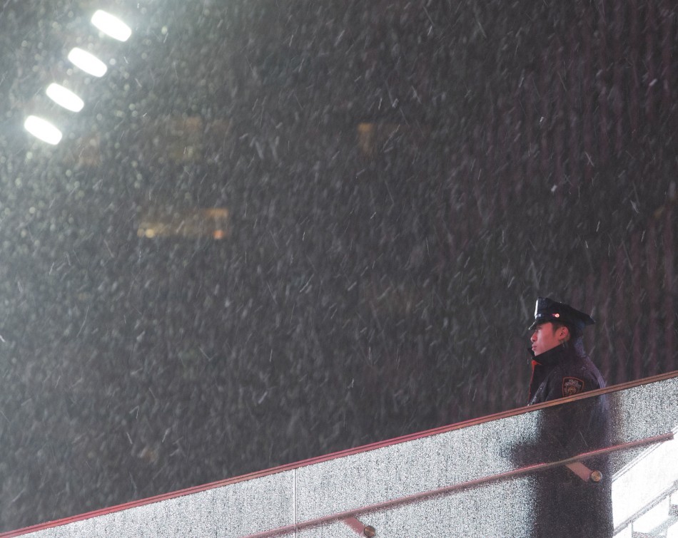 An New York Police Department NYPD officer stands guard at Times Square as snow falls