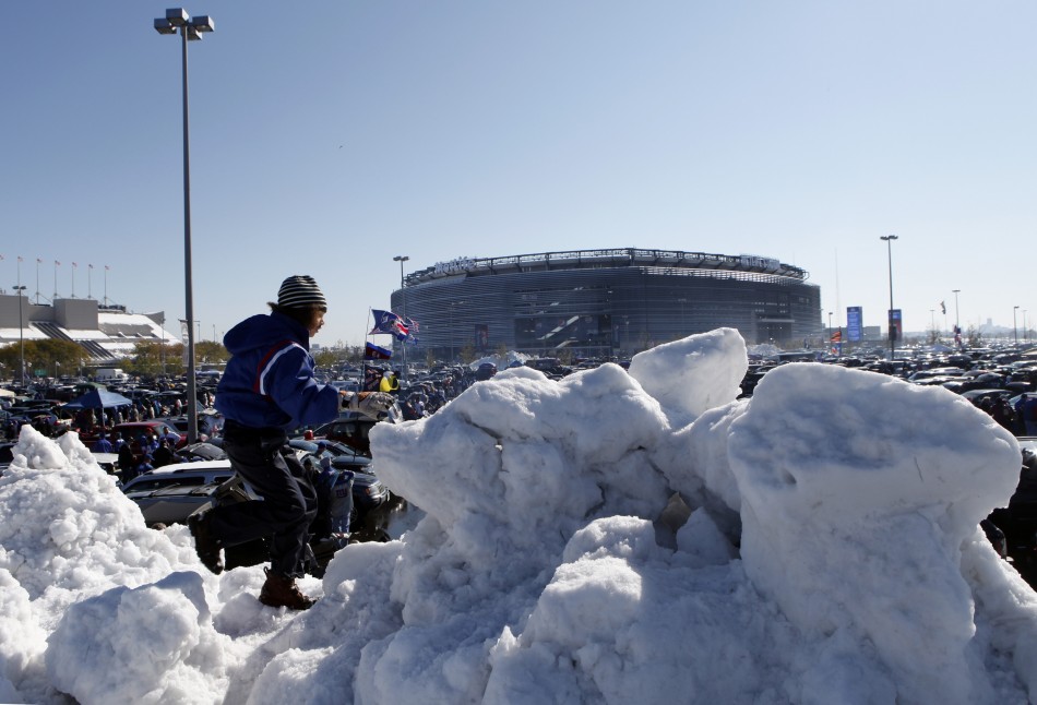 Margaux Lesser from Teaneck, New Jersey, climbs on a giant pile of snow in the parking lot at MetLife Stadium before the NFL football game in East Rutherford