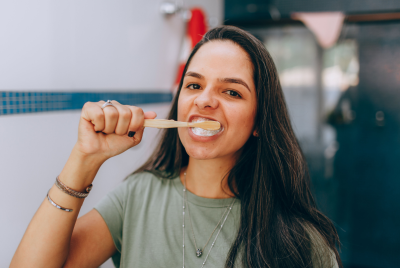 Portrait of a young woman brushing her teeth