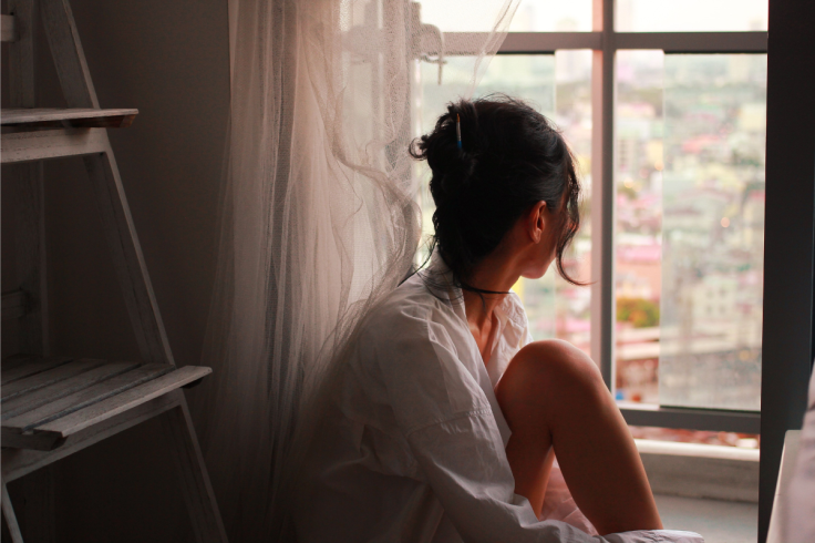 A woman looks out of a window