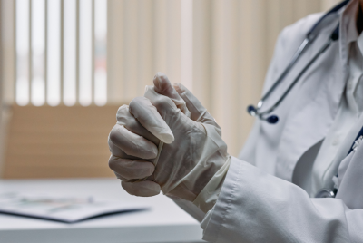 Close-up of a medical professional's hands, wearing latex gloves