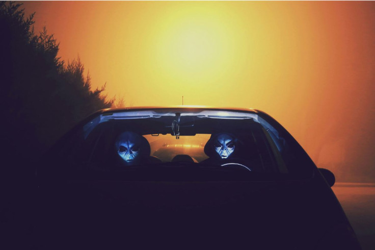 Two Aliens Driving a Vehicle