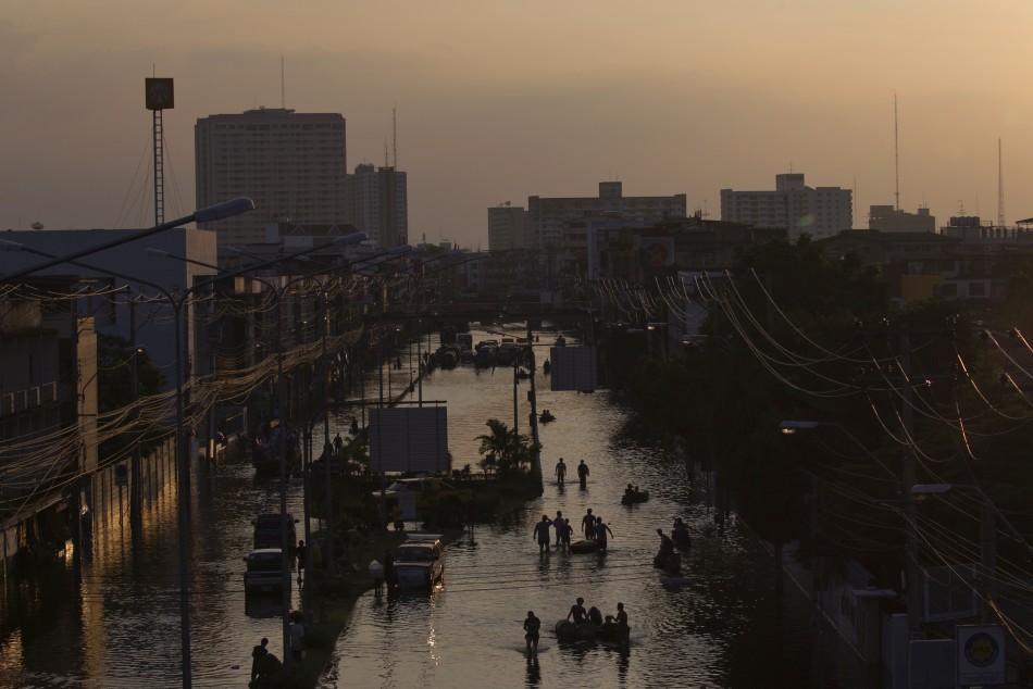 Residents wade through flood waters in Bangkoks Bang Phlat district