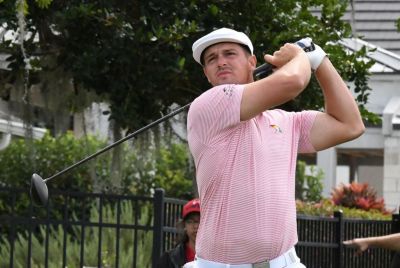 Golfer DeChambeau follows through a swing.