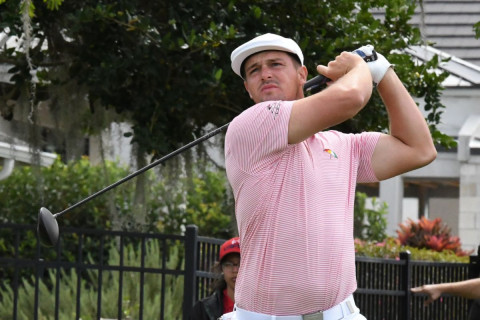 Golfer DeChambeau follows through a swing.