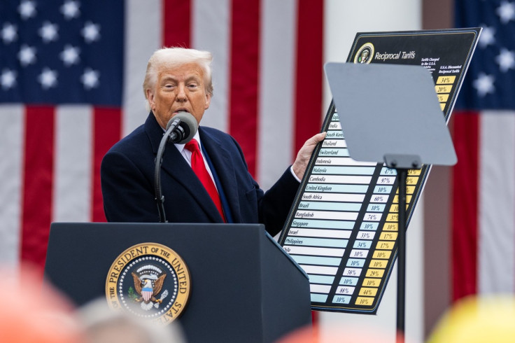 President Donald Trump stands at a lectern, tariff percentages