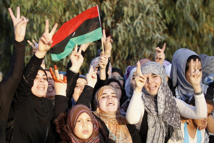Libyans celebrating the return of anti-Gaddafi fighters from Sirte gesture as they welcome them back in Misrata
