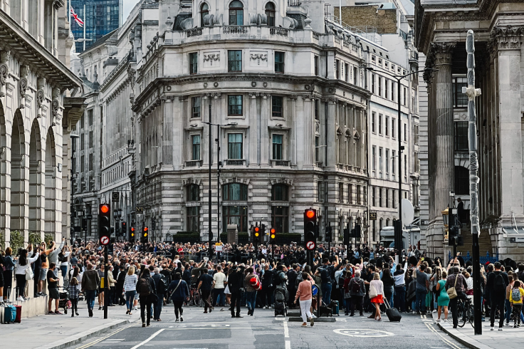 Large crowd gathered at a London city-centre junction surrounded by ornate historic buildings