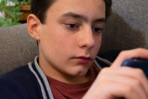 A teenage boy using his phone