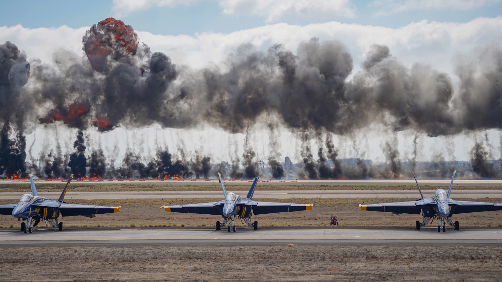 Dynamic scene featuring Blue Angels jets amid smoke