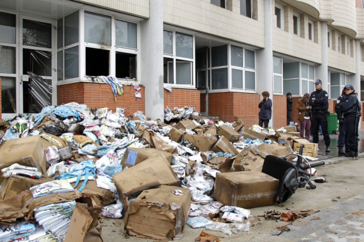 French police stand in front of the damaged offices of French satirical magazine Charlie Hebdo in Paris