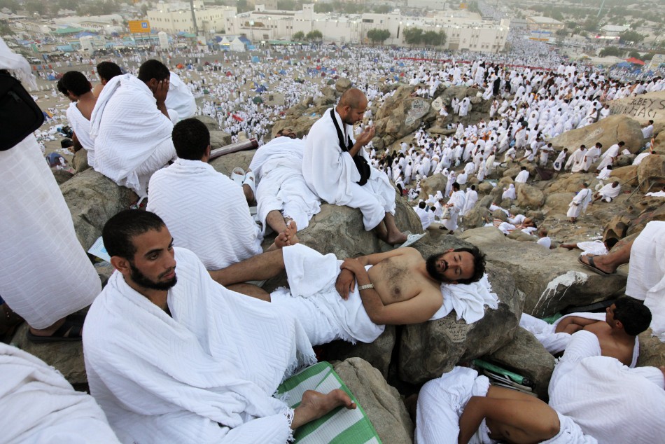 Muslim pilgrims rest as others pray on Mount Mercy on the plains of Arafat