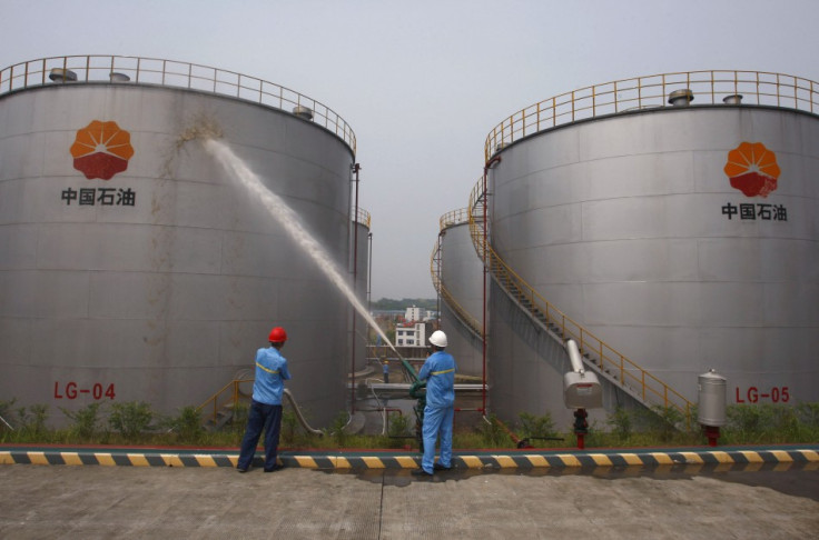 Employees spray water to cool down oil tanks at a PetroChina oil storage facility in Suijing, Sichuan Province, China