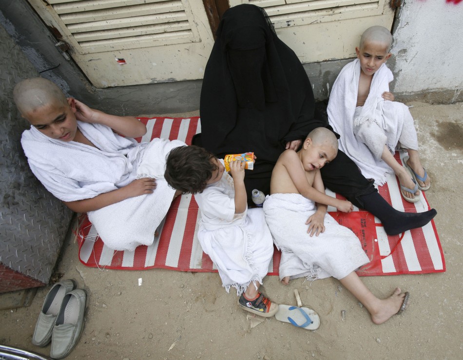 A family of Muslim pilgrims rest after casting seven stones at a pillar symbolizing Satan in Mena