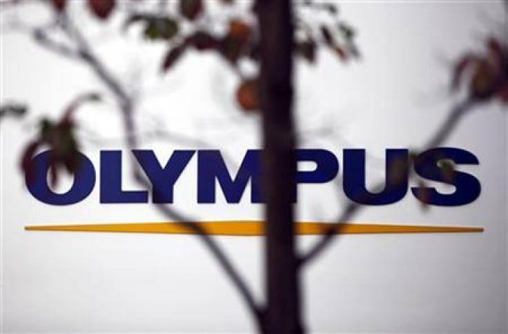 A sign of Olympus Corp is seen behind a tree a outside the company's showroom in Tokyo