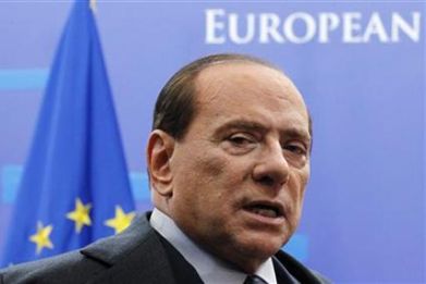 Italy&#039;s Prime Minister Silvio Berlusconi talks to the media as he leaves a euro zone leaders summit in Brussels