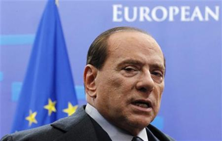 Italy&#039;s Prime Minister Silvio Berlusconi talks to the media as he leaves a euro zone leaders summit in Brussels