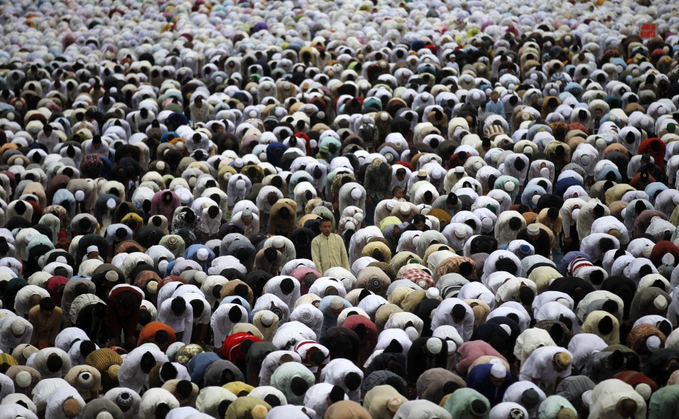 Muslims attend a prayer session along a street in celebration of the Eid al-Adha festival in Jakarta