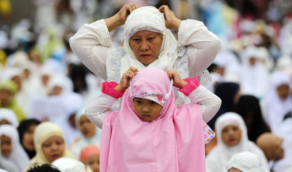A Muslim women and her daughter prepare to attend a prayer session in celebration of Eid al-Adha in Jakarta