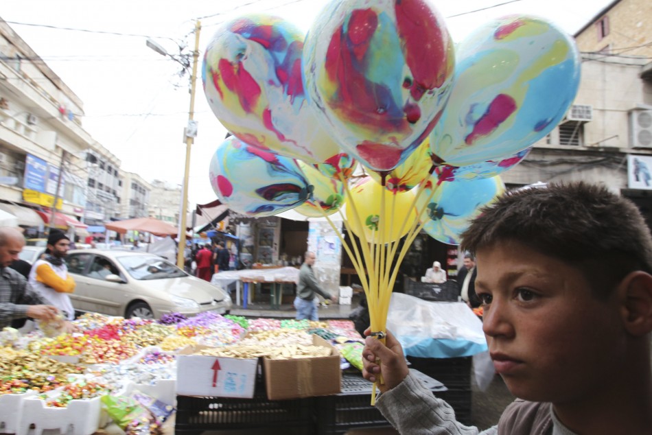 A boy carries balloons for sale ahead of Eid al-Adha in Sidon, Lebanon