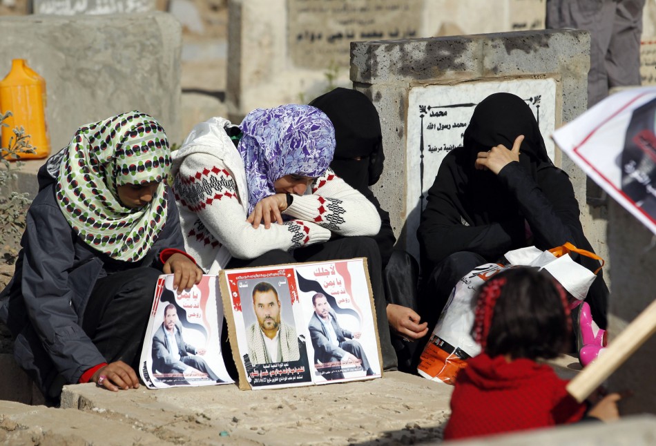 Women react next to their fathers grave in a cemetery during the Muslim festival of Eid al al-Adha in Sanaa
