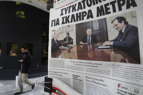 A pedestrian walks past Greek newspapers on sale in Athens November 7, 2011. Greek political leaders were set to choose who will lead a new coalition on Monday and push through a bailout before the country runs out of money in mid-December, with local med