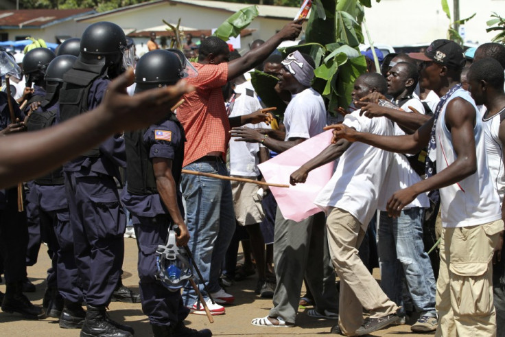 Supporters of presidential challenger Winston Tubman confront riot police as they protest in Monrovia