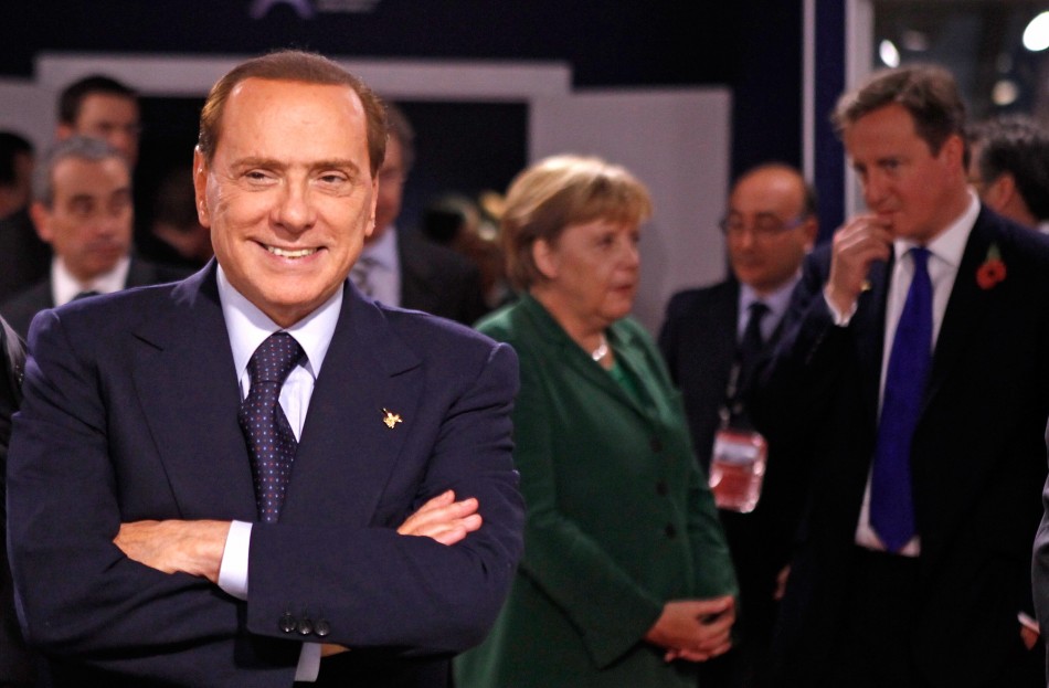 Italys PM Berlusconi looks on as Germanys Chancellor Merkel and Britains PM Cameron talk during the G20 summit in Cannes