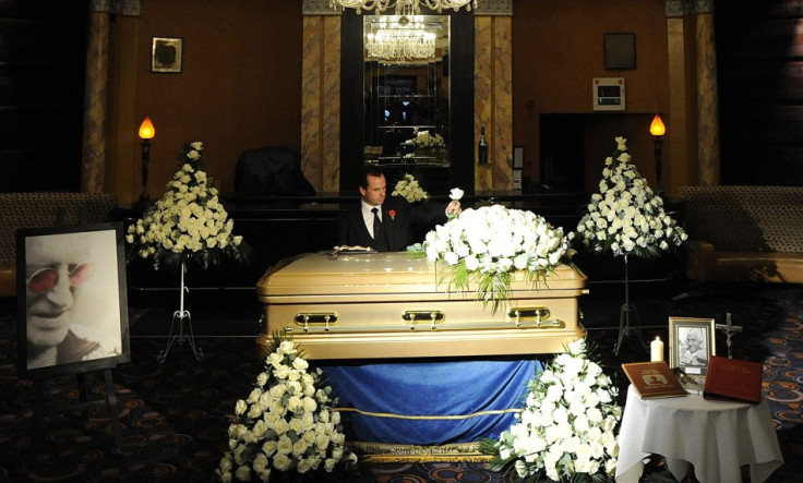 Funeral director Robert Morphet stands by the coffin of British entertainer Jimmy Saville, as it is displayed to the public at The Queens Hotel in Leeds