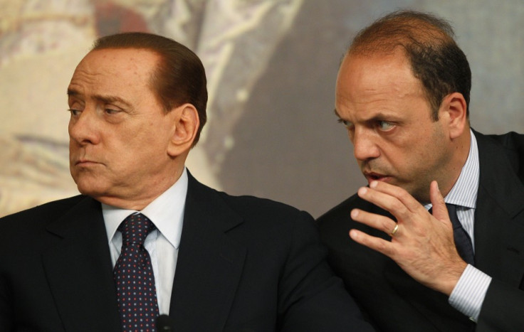 Italian Justice Minister Alfano talks with Prime Minister Berlusconi during a news conference in Rome