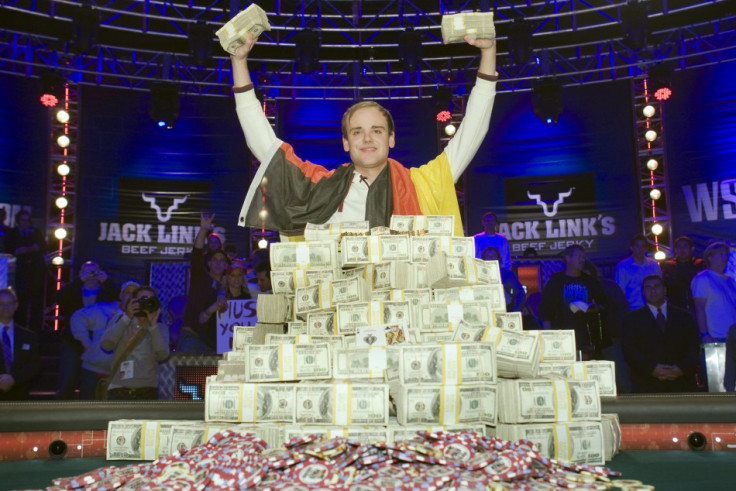Pius Heinz of Germany poses with stacks of cash after beating Martin Staszko of the Czech Republic to win the championship bracelet and $8.7 million in prize money during the World Series of Poker main event at the Rio hotel-casino in Las Vegas